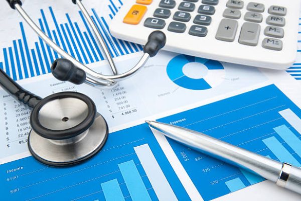 Stethoscope with financial statement, calculator and pen